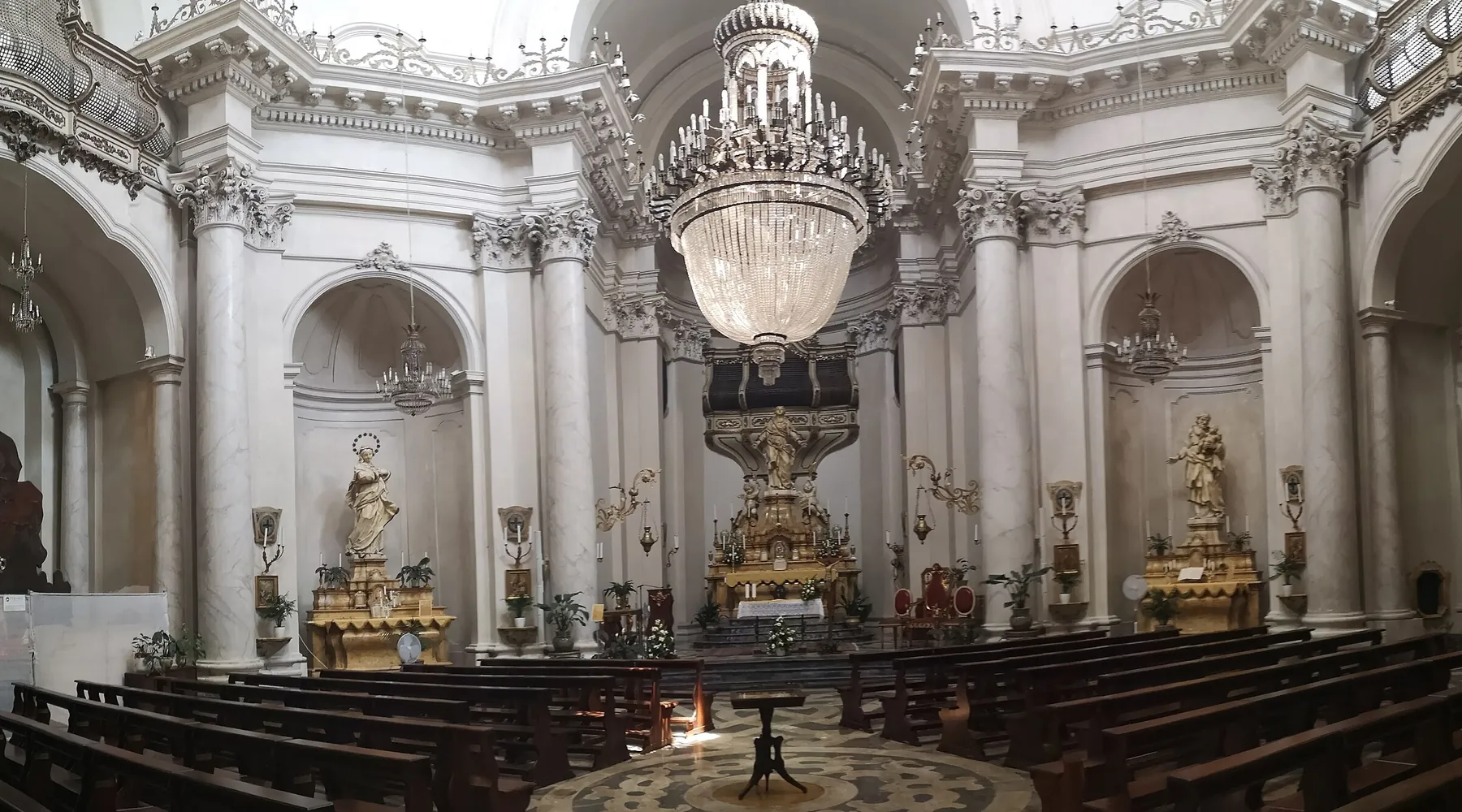 Loď Badia di Sant'Agata s bílými mramorovými sloupy, křišťálovým lustrem, dřevěnými lavicemi a pozlaceným oltářem.